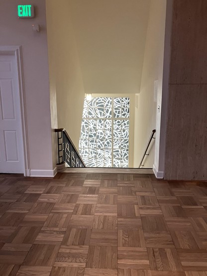 photo of a staircase with a black and white abstract piece at the bottom