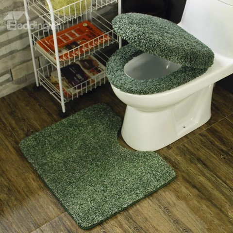 Dark green carpet covers a toilet seat cover and toilet seat, with matching floor mat. Height of trend. Much hygiene.