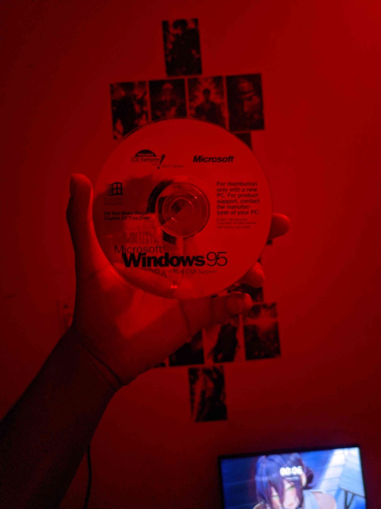 a hand holding a Windows 95 CD